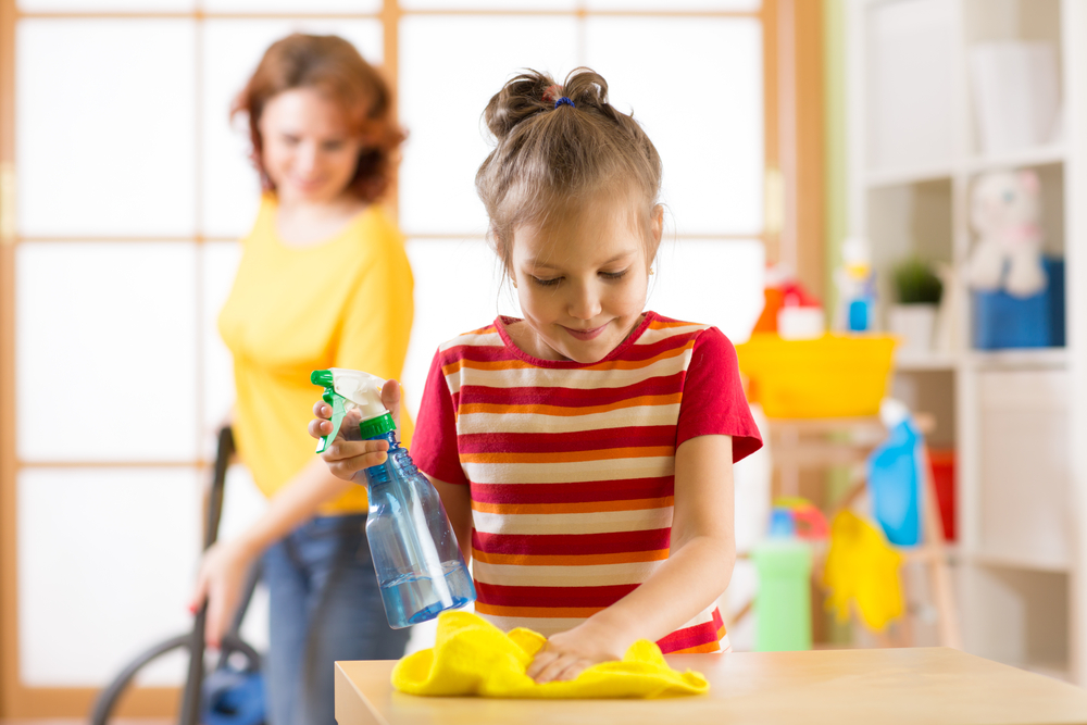 Menina ajuda a mãe a limpar a casa